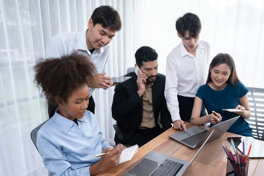 Happy diverse business people work together, discussing in corporate office. Professional and diversity teamwork discuss business plan on desk with laptop. Modern multicultural office worker. Concord