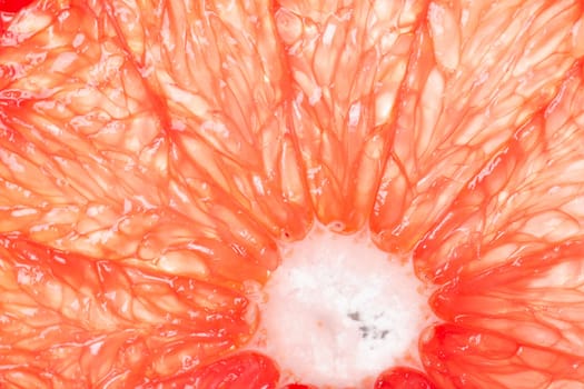 The texture of a red grapefruit in the section with the center, a macrophotography of fruits