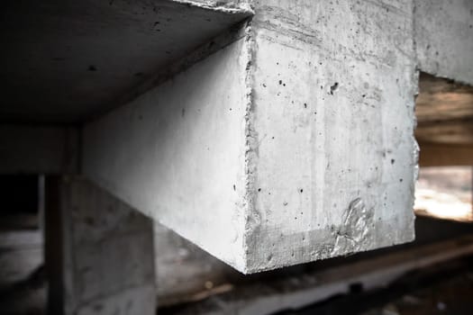 Reinforced concrete structure of columns, beams and floors of a building under construction. Close-up on a beam.
