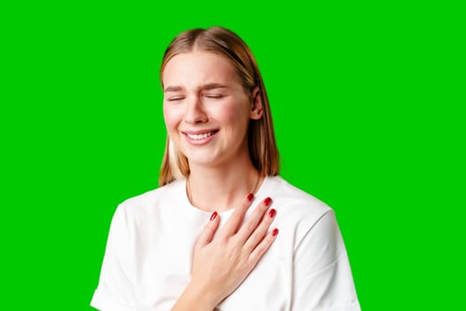 Portrait of an upset young casual girl against green background in studio