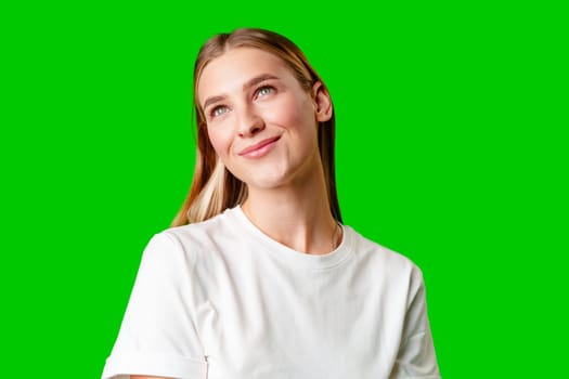 Young Woman in White Shirt Posing for Picture against green background in studio