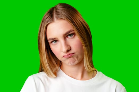 Young Woman With Pursed Lips Expressing Skepticism Against Green Screen Background in studio