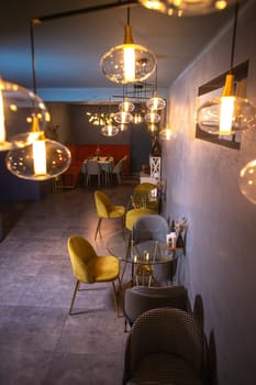 Elegant restaurant with dim lighting, stylish furniture, dark walls, tables, chairs, bar, and kitchen for romantic dinners.