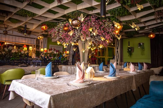 The image shows a beautifully decorated restaurant interior with a floral-adorned ceiling and elegant table settings.