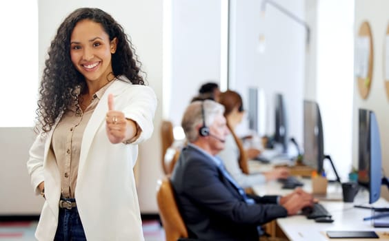 Portrait, woman and thumbs up with smile in working for call center or customer care in office with coworkers. Female person, consultant and agent for telecommunication, company and workplace or job.