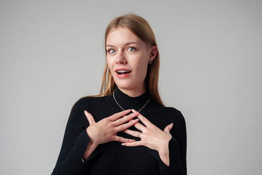 Young Woman Holding Hands Together in Black Shirt in studio close up