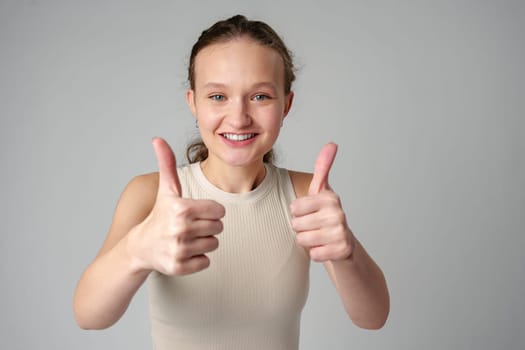 Young Girl Giving Thumbs Up Sign in studio close up