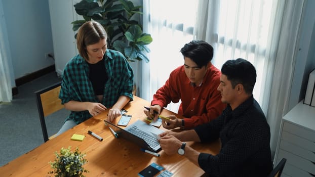 Top down view of project manager present startup project while caucasian investor writing idea and looking at laptop screen display program. Creative business team discussing strategy. Convocation.