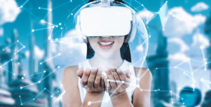 Female standing wearing white VR headset and white sleeveless connecting metaverse, future technology create cyberspace community. She holding and seeing 3d hologram of global picture. Hallucination.