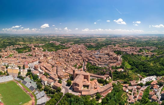 Aerial view of Siena, medieval town in Tuscany, with view of the Dome and Bell Tower of Siena Cathedral (Duomo di Siena), landmark Mangia Tower and Basilica of San Domenico,Italy