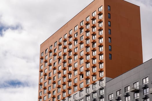 Residential complex in Moscow. New buildings in Moscow, high-rise bright creative house and against the sky. There are many apartments with Windows.