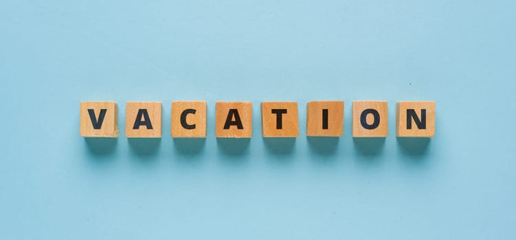 Vacation is written on wooden cubes on a blue background