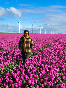 A graceful woman stands among a vibrant field of purple tulips, bathed in the soft light of a Spring day in the Netherlands.