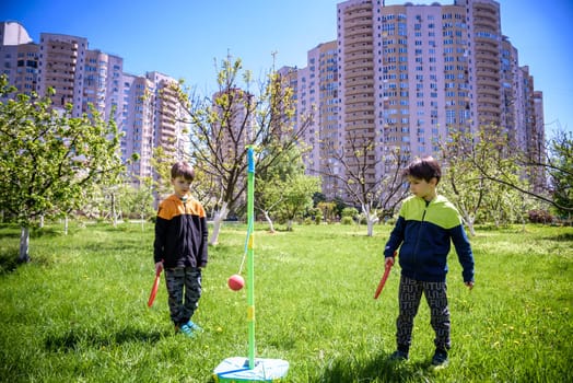 Two friends are playing tetherball swing ball game in summer camping. Two boy brother happy leisure healthy active time outdoors concept.