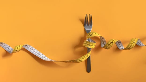 Fork with measuring tape on yellow background. Weight loss and healthy concept.