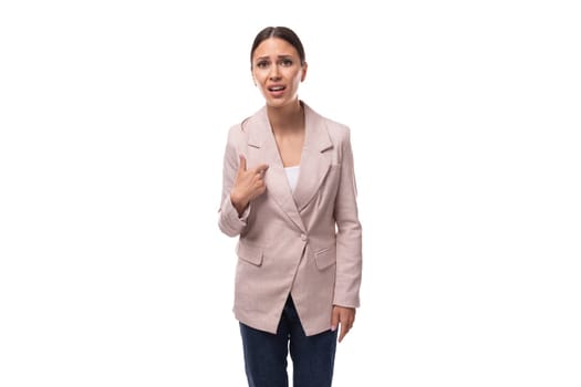 well-groomed young caucasian woman with collected black hair in a ponytail is dressed in a beige jacket doubts.