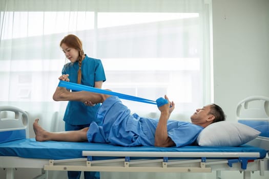 A sick caregiver or young nurse is helping a patient who is rehabilitating with physical therapy at the hospital..