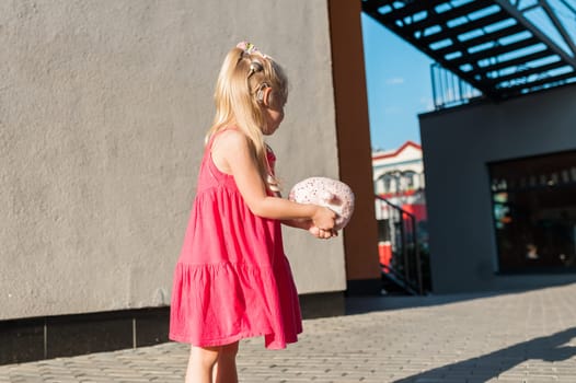 Funny baby with cochlear implant walks outdoor. Hearing aid and medicine innovating technology concept. Diversity and inclusion. Copy space.