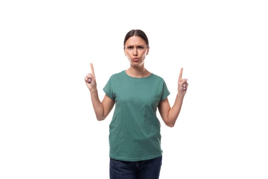 young black-haired woman in a green basic t-shirt with surprise tells the news.