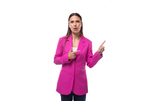 young stylish business assistant woman dressed in a bright pink jacket points her hand to the side.