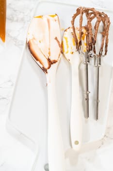 A cluttered kitchen counter covered in used baking ingredients and tools after making cupcakes.