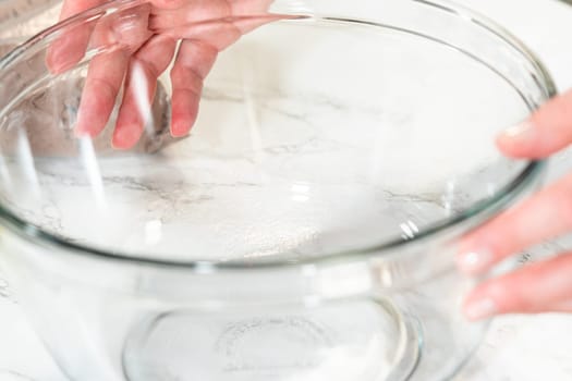 In the process of creating mouthwatering chocolate cupcakes, the first step involves meticulously mixing the ingredients in a glass mixing bowl to make the perfect batter.