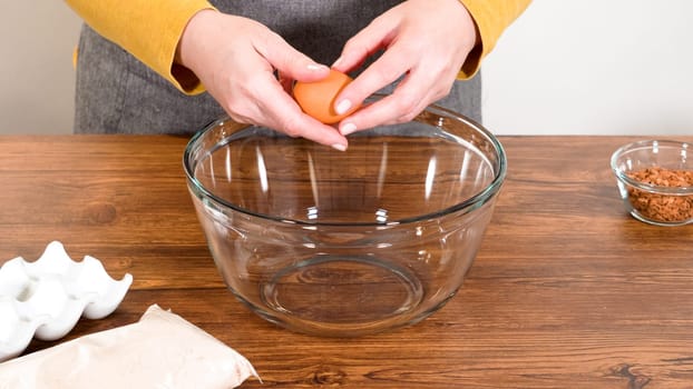 In a glass mixing bowl, a large hand whisk expertly blends the ingredients for a delectable gingerbread bundt cake with caramel frosting.