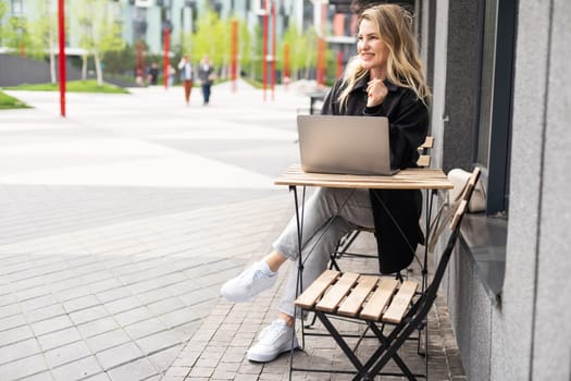 Young woman with laptop outside. High quality photo