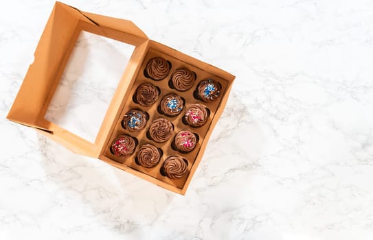 Flat lay. Preparing to share the delicious chocolate cupcakes, the final step involves carefully packaging them into a brown paper cupcake box.