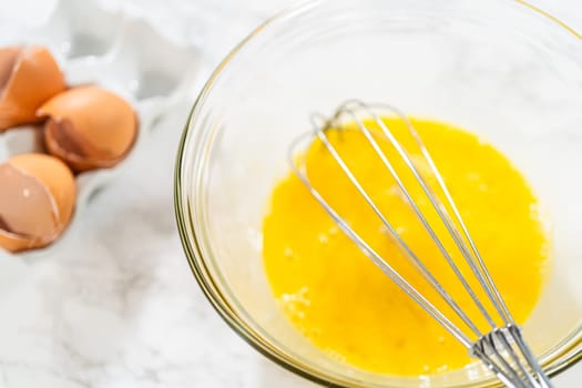 In the process of creating mouthwatering chocolate cupcakes, the first step involves meticulously mixing the ingredients in a glass mixing bowl to make the perfect batter.