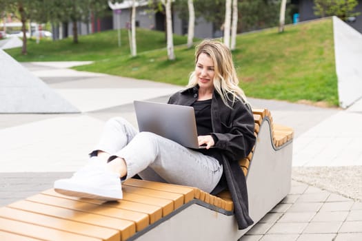 Young woman with laptop outside. High quality photo