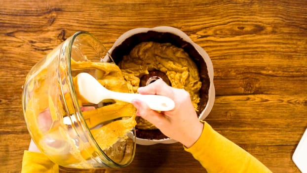 Flat lay. Pouring the gingerbread cake batter into the greased bundt cake pan, ready for a delightful caramel frosting.