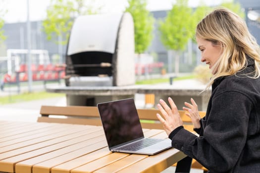 Young beautiful business woman sitting on a bench in the sunny city. High quality photo