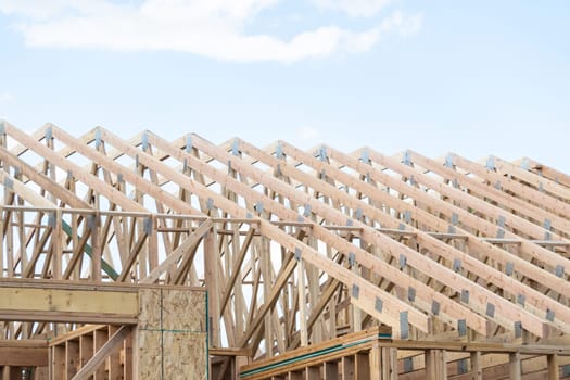 An ongoing construction site in the suburbs, featuring the framing stage of a single-family house.