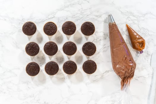 Flat lay. Each chocolate cupcake receives a generous filling of luscious caramel, adding an extra layer of flavor and indulgence.