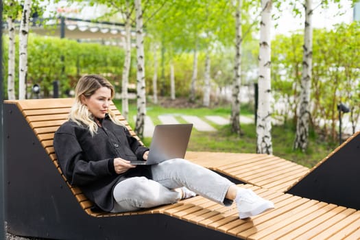 Young woman with laptop outside. High quality photo