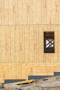 An ongoing construction site in the suburbs, featuring the framing stage of a single-family house.