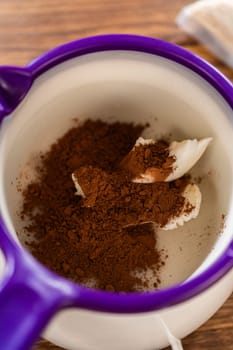 Carefully greasing a bundt cake pan in preparation for baking a delicious gingerbread bundt cake with caramel frosting.