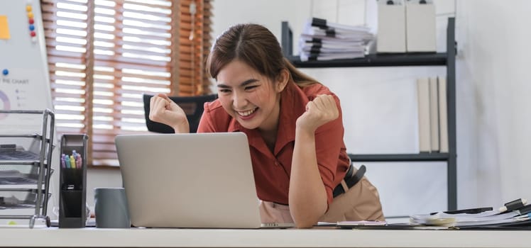 Portrait of Young Asian woman hand freelancer is working her job on computer tablet in modern office. Doing accounting analysis report real estate investment data, Financial and tax systems concept..