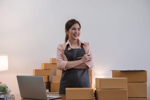 Portrait of Asian young woman SME working with a box at home the workplace.start-up small business owner, small business entrepreneur SME or freelance business online and delivery concept..