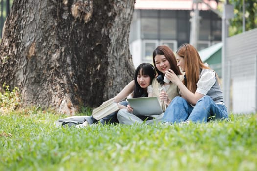 Group Of Young Asian Students Collaborating Outdoors at University. Teamwork and Knowledge Sharing. Asian Students Engaged in Collaborative Learning Outdoors..