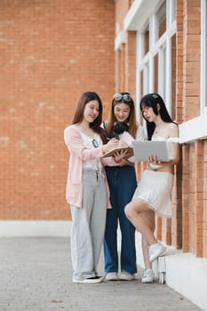 Group of young Asian college students are studying together in university. Students outdoors. Education concept..