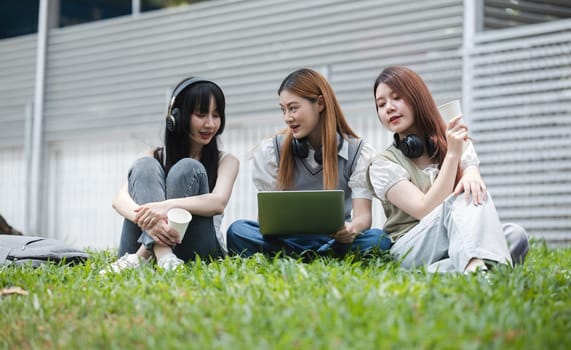 Group Of Young Asian Students Collaborating Outdoors at University. Teamwork and Knowledge Sharing. Asian Students Engaged in Collaborative Learning Outdoors..