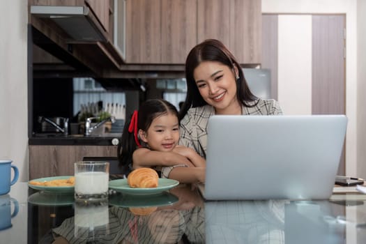 Working mom work from home office. businesswoman and cute child using laptop work freelancer workplace in home, Lifestyle family moment.