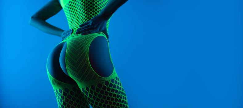 Sexy buttocks close-up of a hot girl in erotic lingerie mesh bodysuit with open crotch in the neon blue light copy paste