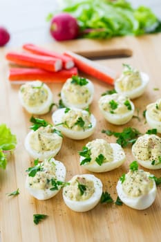 stuffed eggs, deviled eggs on a wooden table .