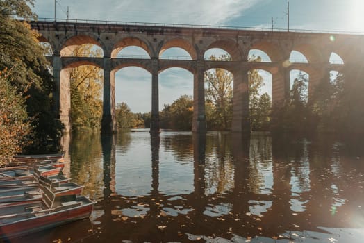 Railway Bridge with river in Bietigheim-Bissingen, Germany. Autumn. Railway viaduct over the Enz River, built in 1853 by Karl von Etzel on a sunny summer day. Bietigheim-Bissingen, Germany. Old viaduct in Bietigheim reflected in the river. Baden-Wurttemberg, Germany. Train passing a train bridge on a cloudy day in Germany