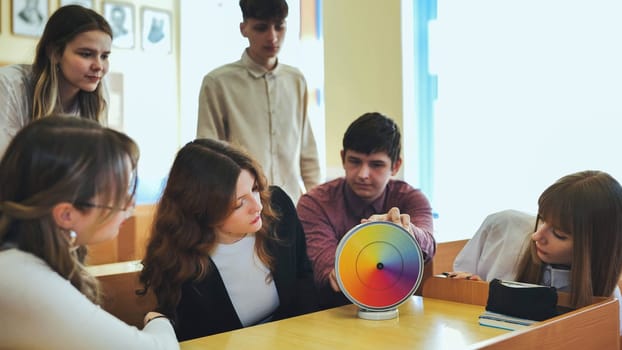 Students in physics class spin Newton's multicolored disk