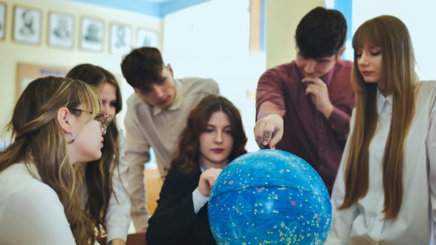 Students look at a globe of the starry sky in a classroom at school