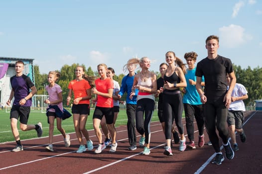 Group of young athletes training at the stadium. School gym trainings or athletics